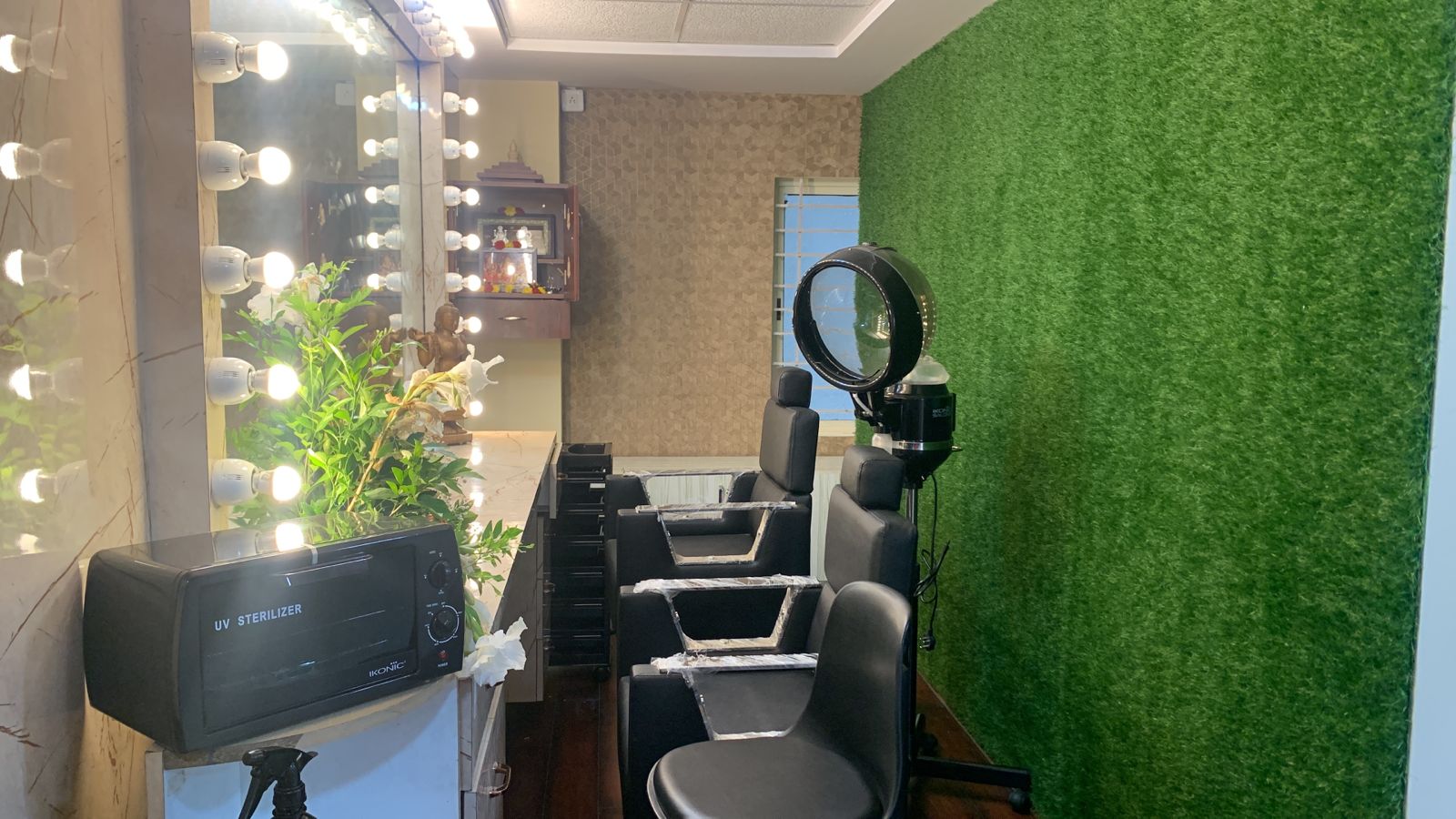 Professional hair styling area with mirrors and green accent wall